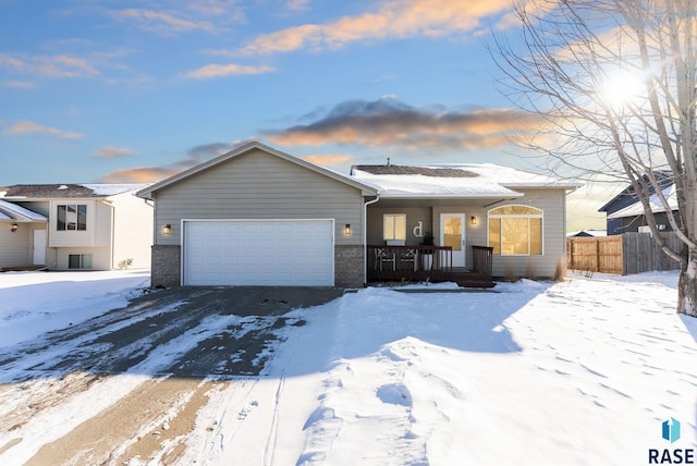 single story home with a garage and fence