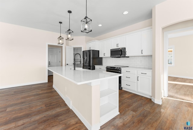 kitchen featuring a center island with sink, stainless steel microwave, white cabinets, and range with electric stovetop