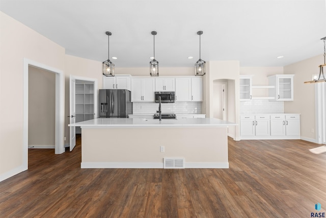 kitchen featuring visible vents, glass insert cabinets, stainless steel appliances, light countertops, and white cabinetry