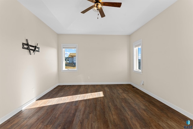 unfurnished room with dark wood-style floors, ceiling fan, baseboards, and a wealth of natural light