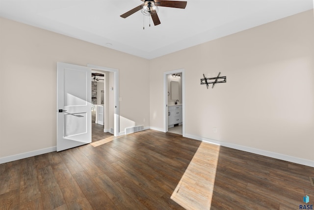 empty room with dark wood-style floors, baseboards, visible vents, and ceiling fan