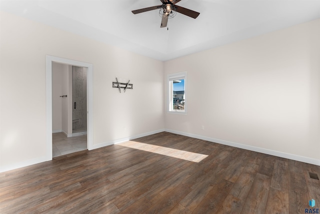 unfurnished room with dark wood-style flooring, a ceiling fan, and baseboards