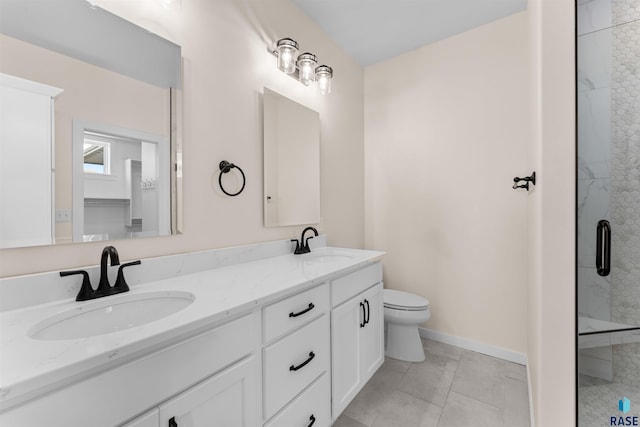 bathroom featuring double vanity, a shower stall, toilet, and a sink