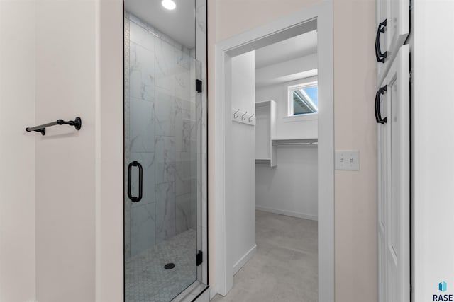 bathroom featuring a marble finish shower and baseboards