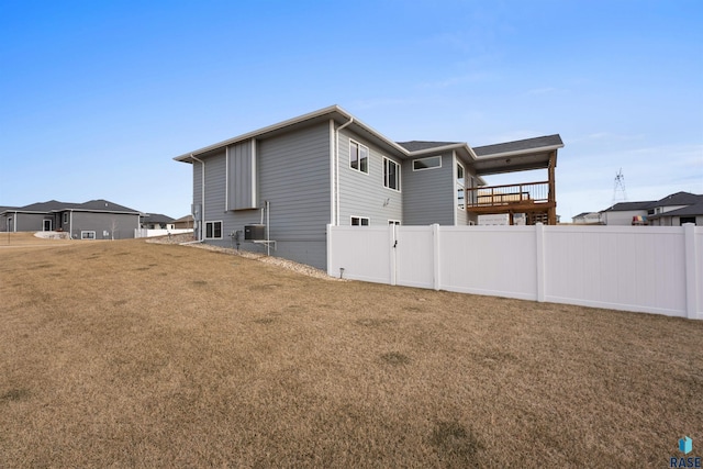 view of property exterior featuring a lawn and fence