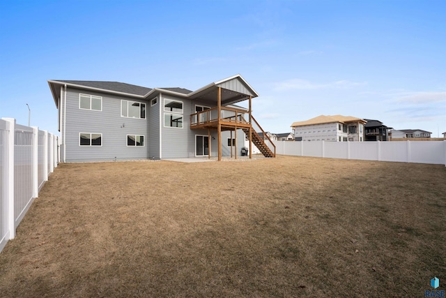 rear view of property with a fenced backyard, stairs, a deck, and a lawn