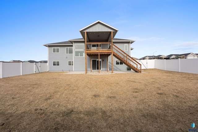 rear view of property with a deck, a fenced backyard, a lawn, and stairway