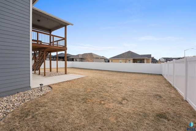 view of yard with a fenced backyard, stairs, a residential view, and a wooden deck