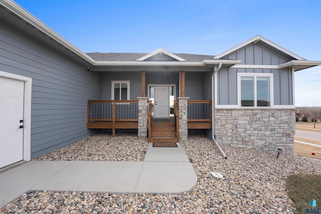 view of front of property with board and batten siding, covered porch, and stone siding