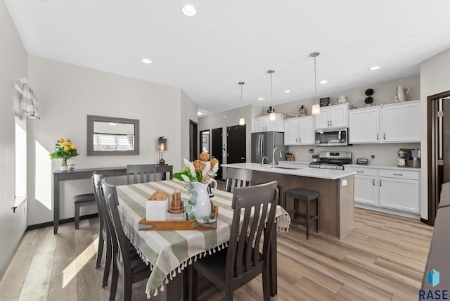 dining space with light wood-type flooring, baseboards, and recessed lighting