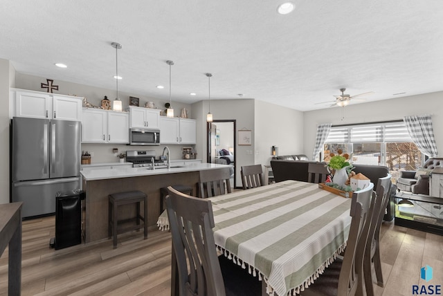 dining area with a textured ceiling, light wood finished floors, a ceiling fan, and recessed lighting