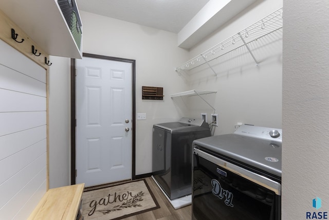 laundry area featuring dark wood-type flooring, laundry area, and washing machine and clothes dryer