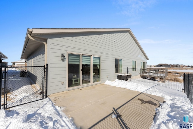 snow covered house featuring fence