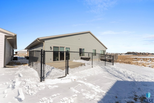 snow covered house with fence