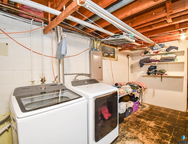 laundry room with laundry area, washing machine and dryer, and electric panel