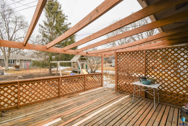 deck with visible vents, a pergola, and a playground