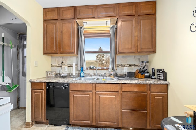 kitchen with tasteful backsplash, light countertops, dishwasher, and a sink