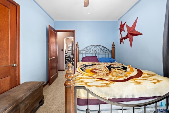 bedroom with light carpet, arched walkways, a ceiling fan, and ornamental molding