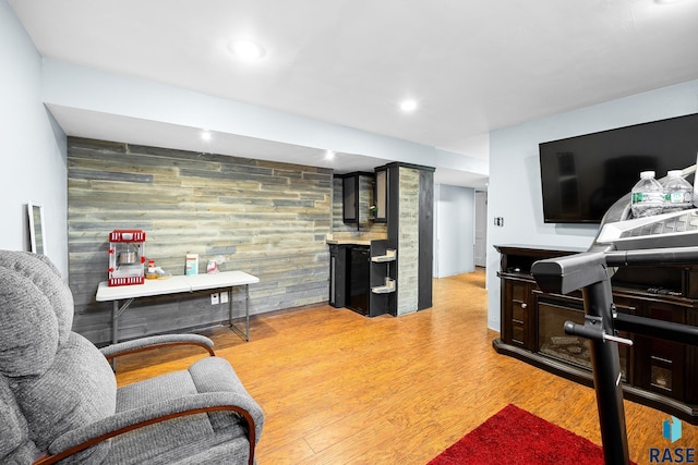 interior space featuring an accent wall, recessed lighting, light wood-style floors, and wood walls