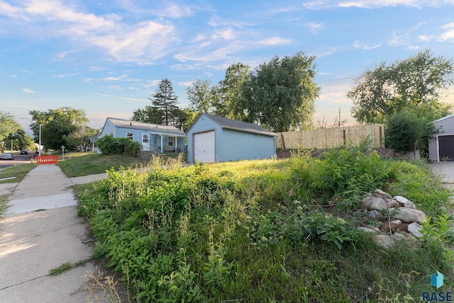 view of front of home with an outbuilding, fence, and a garage