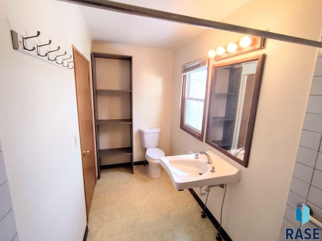 bathroom with a sink, toilet, and tile patterned floors