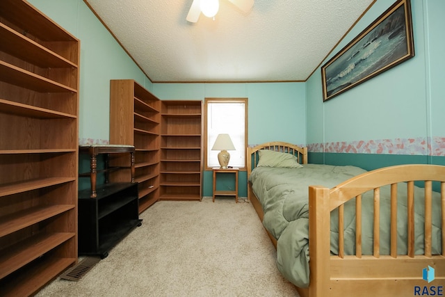 bedroom with light carpet, crown molding, a textured ceiling, and ceiling fan