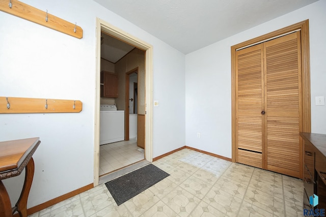 interior space with light floors, washer / dryer, and baseboards