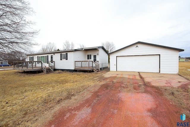 view of front of property with a deck, a front lawn, an outdoor structure, and a garage