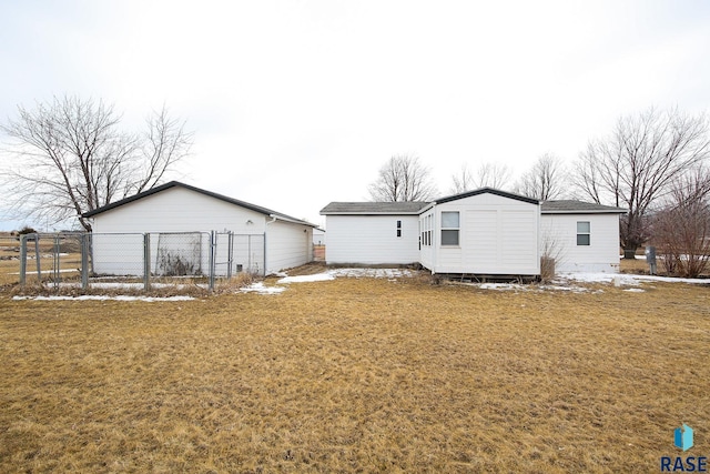 rear view of house with a yard and fence