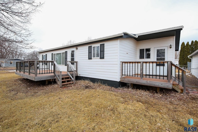 back of house featuring a yard and a wooden deck