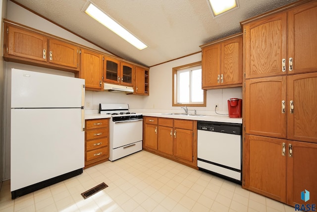 kitchen featuring lofted ceiling, light countertops, glass insert cabinets, white appliances, and under cabinet range hood