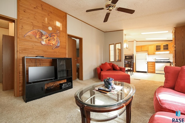 living room featuring light colored carpet, wood walls, a textured ceiling, and ceiling fan