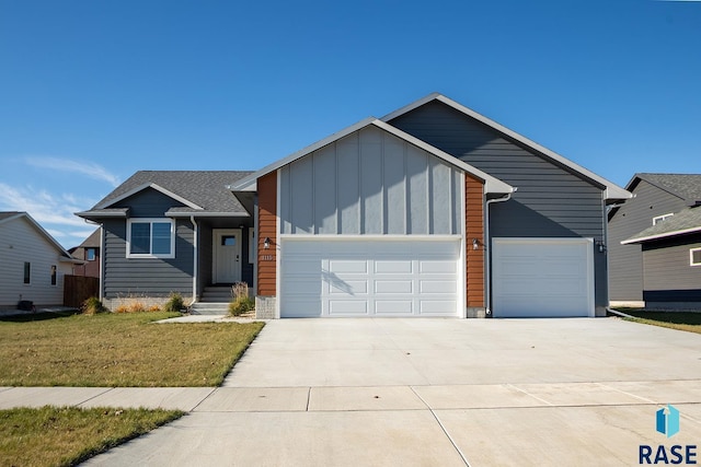 view of front of house with driveway, board and batten siding, an attached garage, and a front yard