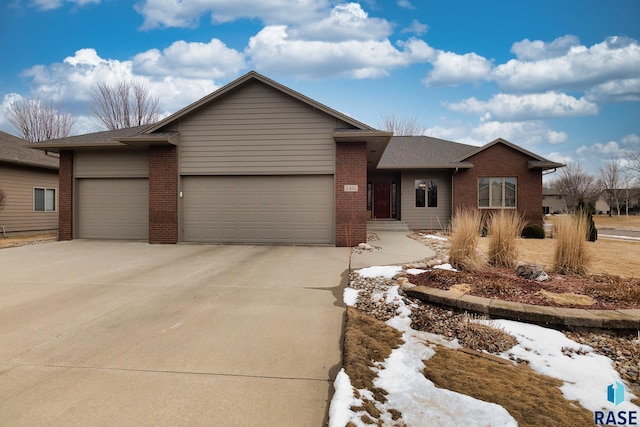 ranch-style house with a garage, concrete driveway, and brick siding