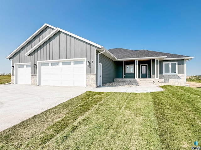 view of front of house with a garage, concrete driveway, board and batten siding, and a front yard