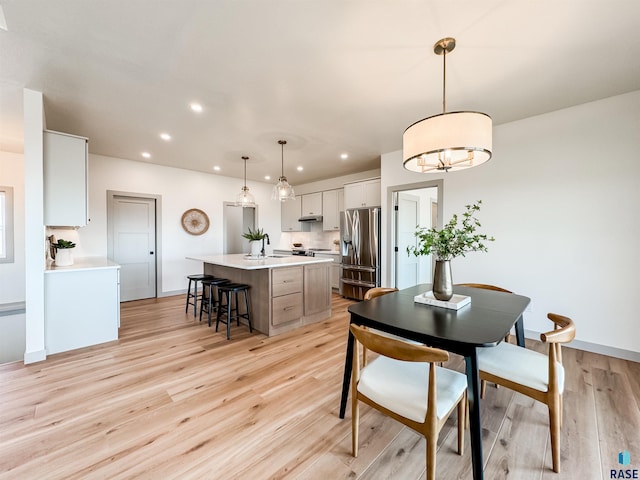 dining area with recessed lighting, baseboards, and light wood finished floors