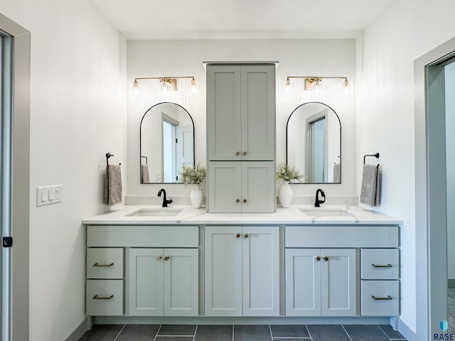 full bathroom featuring a sink, baseboards, and double vanity