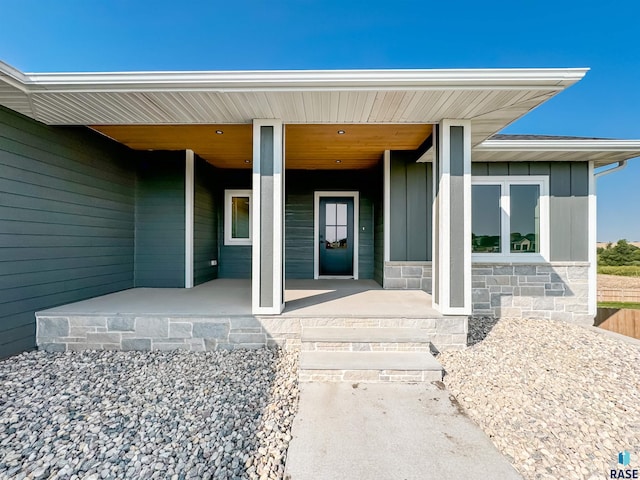 doorway to property featuring covered porch and board and batten siding