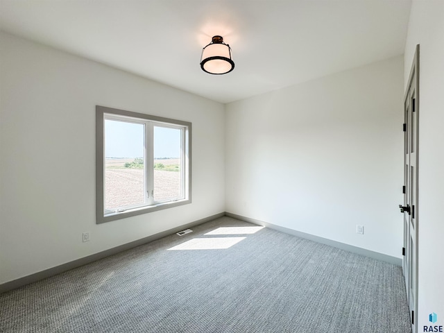 spare room with light carpet, baseboards, and visible vents