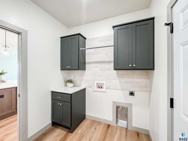 laundry room with light wood finished floors, cabinet space, hookup for a washing machine, and electric dryer hookup