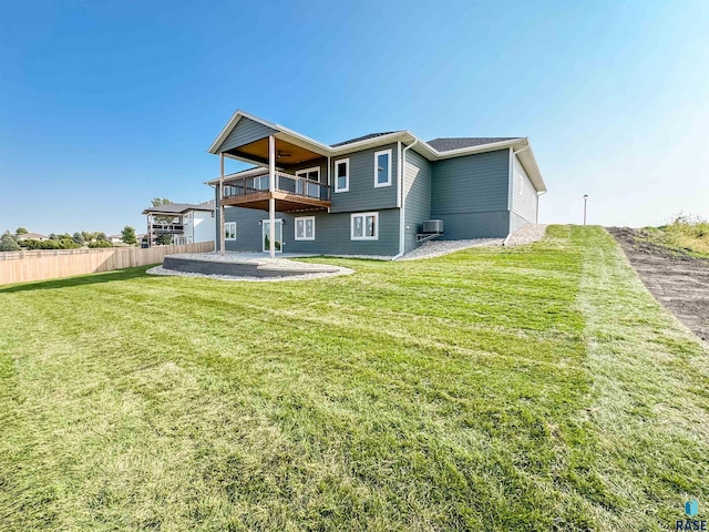 rear view of house featuring a lawn, a patio area, and fence