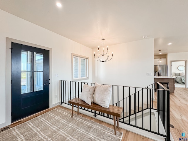 foyer with visible vents, baseboards, light wood-style floors, a chandelier, and recessed lighting