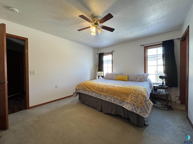 bedroom with a ceiling fan, carpet, baseboards, and a textured ceiling