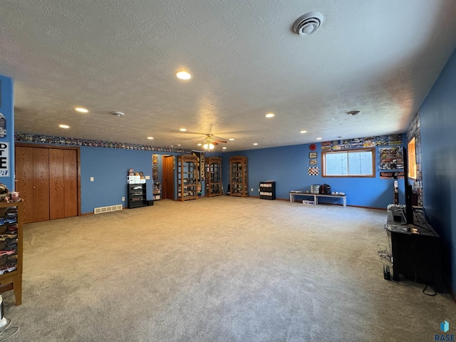 interior space with carpet floors, visible vents, and a textured ceiling