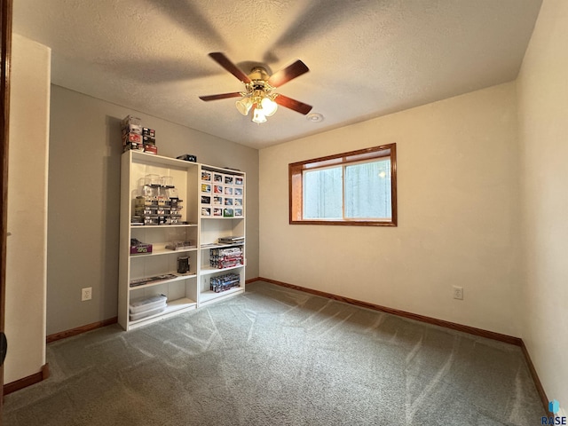 carpeted spare room featuring a ceiling fan, a textured ceiling, and baseboards