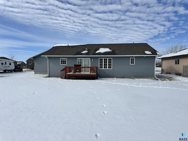 snow covered house with a deck