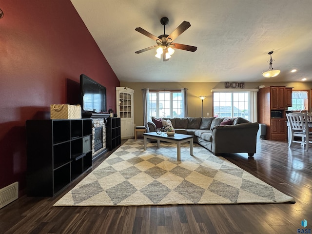 living room with lofted ceiling, a wealth of natural light, visible vents, and wood finished floors