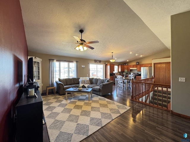 living area featuring lofted ceiling, a ceiling fan, a textured ceiling, wood finished floors, and baseboards