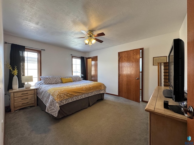 carpeted bedroom with a textured ceiling, a ceiling fan, and baseboards