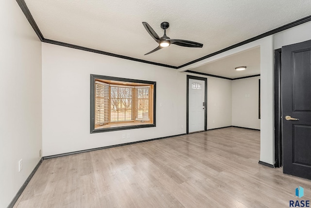 spare room with light wood-style flooring, ornamental molding, and a textured ceiling